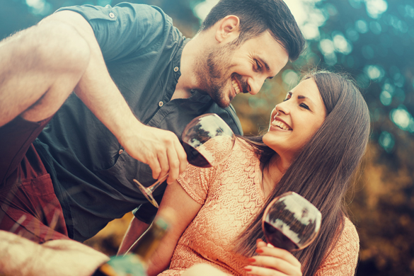 Cute young couple drinking red wine on a picnic in park - Facts about dating a Scorpio Man