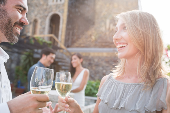 Cheerful couple flirting at outdoor cocktail party - Reasons Women find Scorpio Men So Irresistible