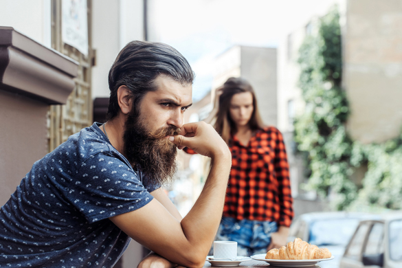 Unhappy man hipster with long beard and moustache has relationship difficulties with pretty girl in cafe outdoors - Why Scorpio Men Hate Being Compared to Other Men