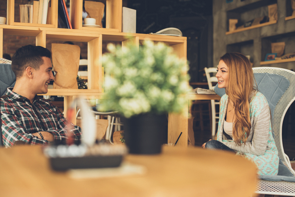 Young man and woman flirting each other in cafe - How to Meet a Scorpio Man