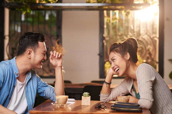 laughing Asian couple enjoying date in cafe - What Types of Things Do Scorpio Men Love To Hear