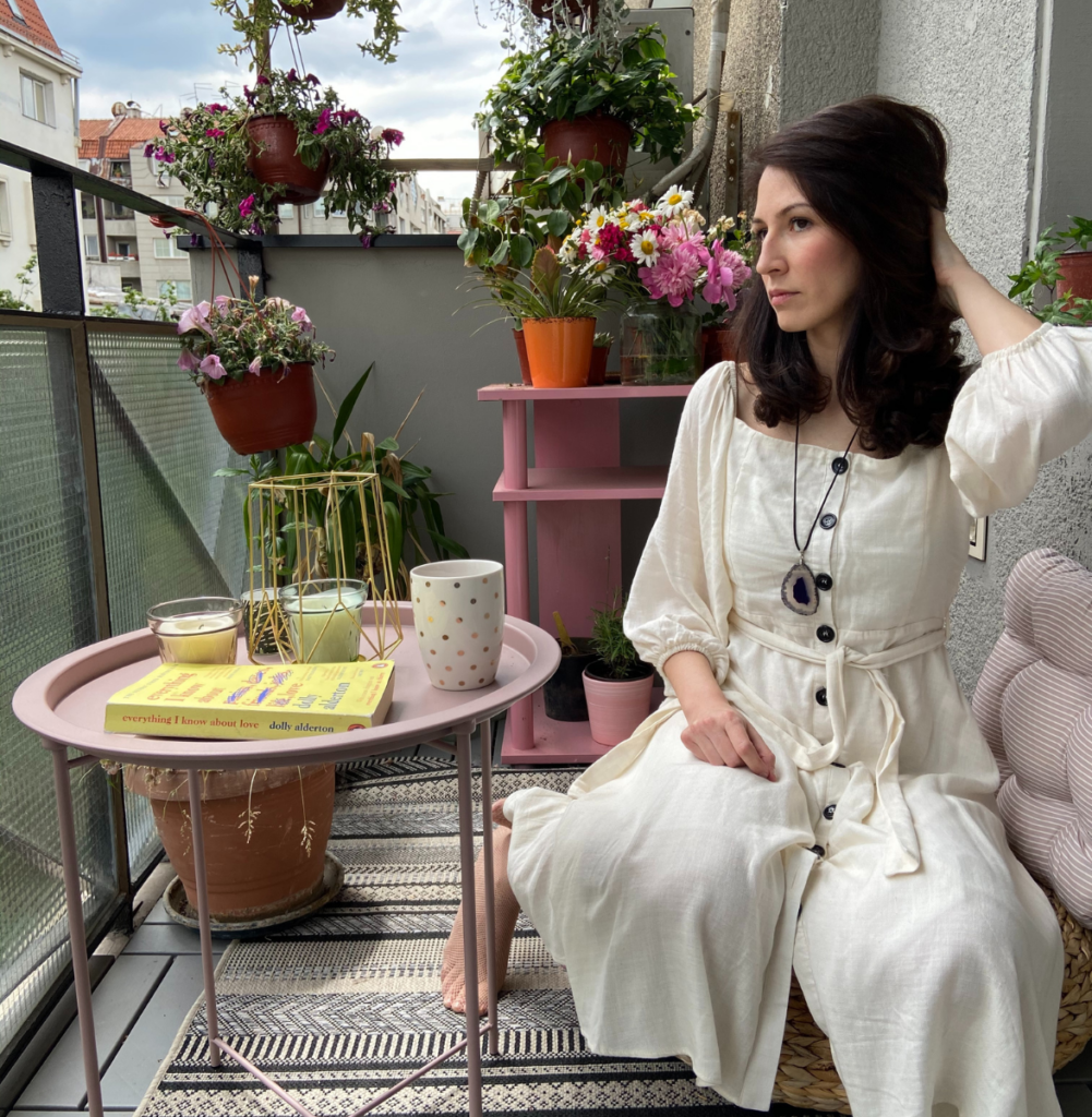 Anna Kovach astrologer posing on her balcony